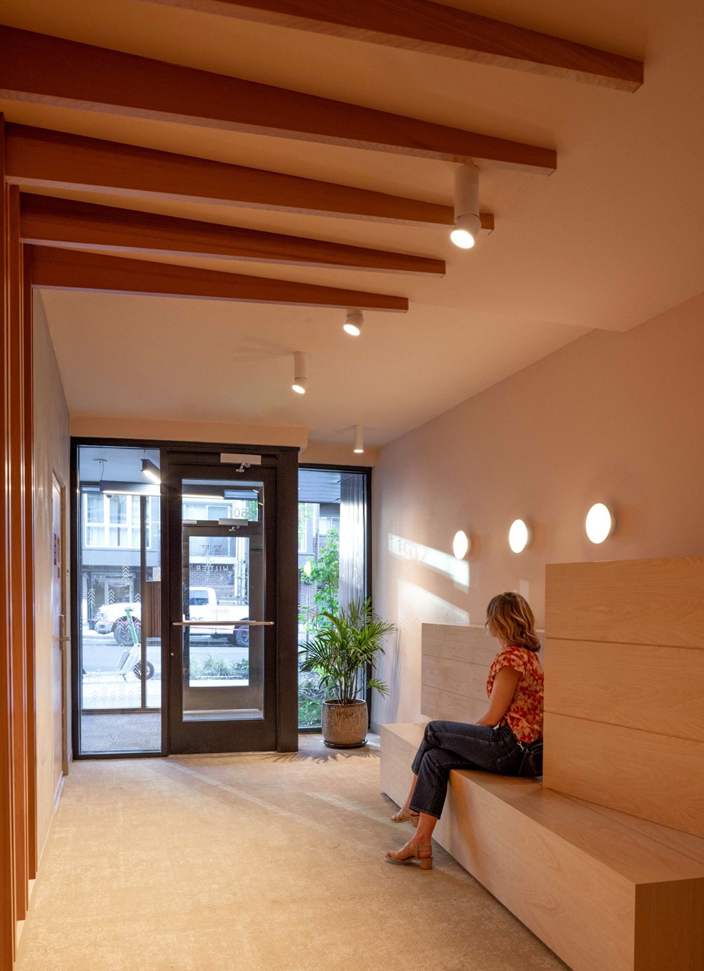 a woman sitting on a bench in a lobby