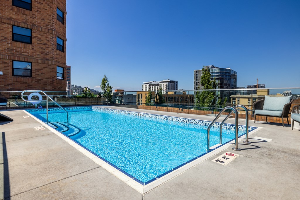 pool on the rooftop of a building with a city in the background