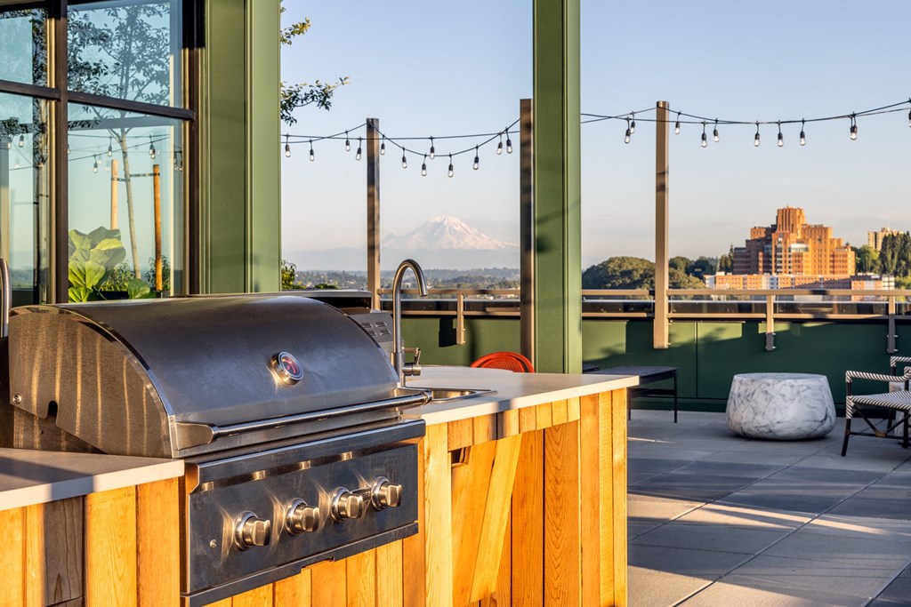 a bbq grill on a patio with a view of a mountain