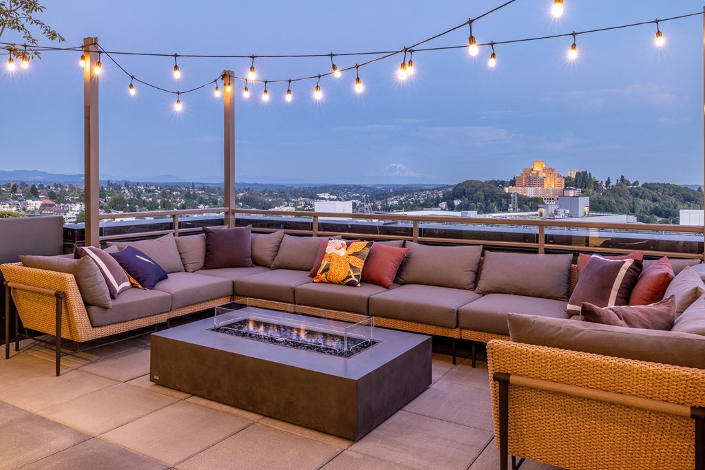 a rooftop patio with couches and a fire pit