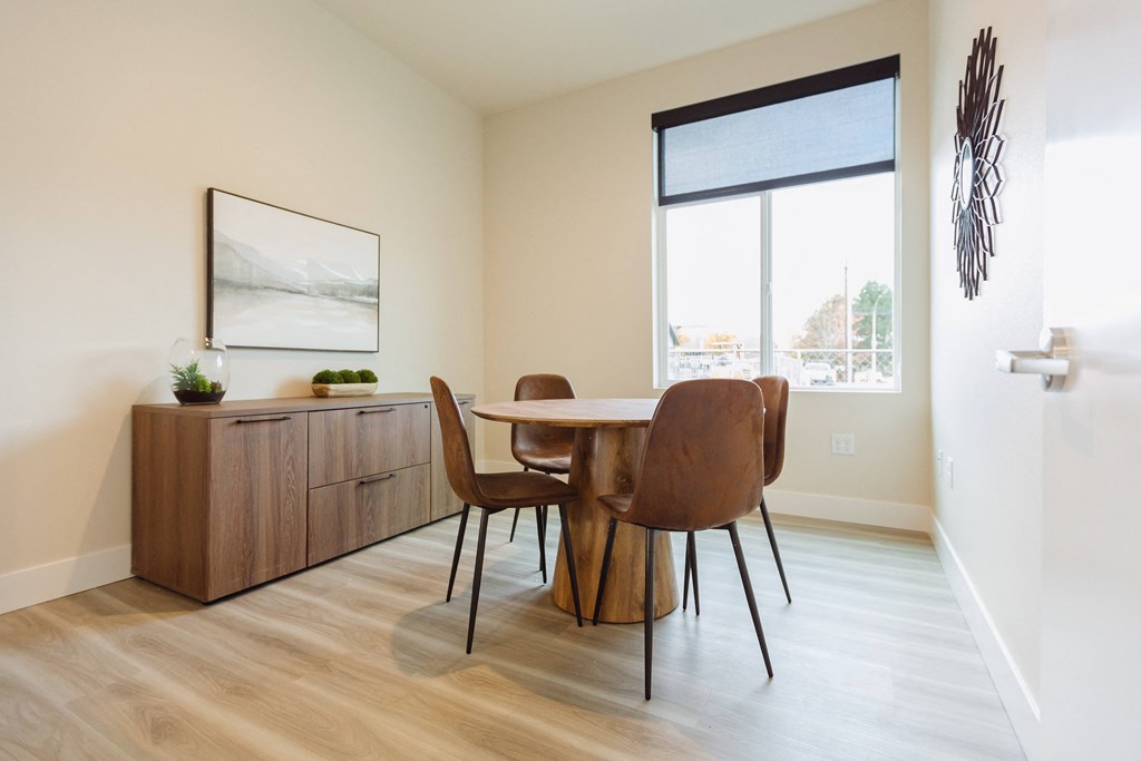 A dining room with a wooden table and chairs.