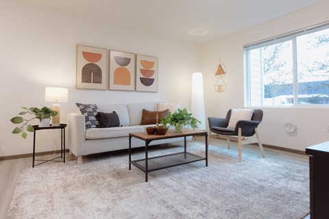 a living room with a couch and a table and a window
