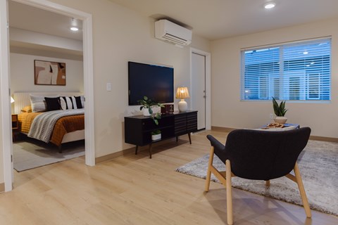 A modern living room with a black chair and a television.