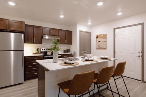 a kitchen with a large island with four chairs