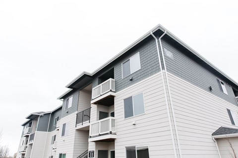 a white and gray apartment building with balconies