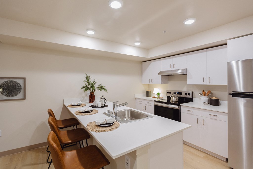 A modern kitchen with white cabinets and a large island.
