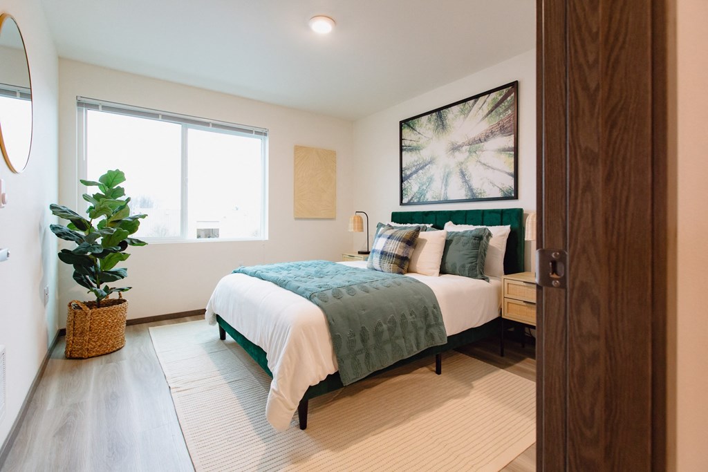 a bedroom with a bed and a potted plant