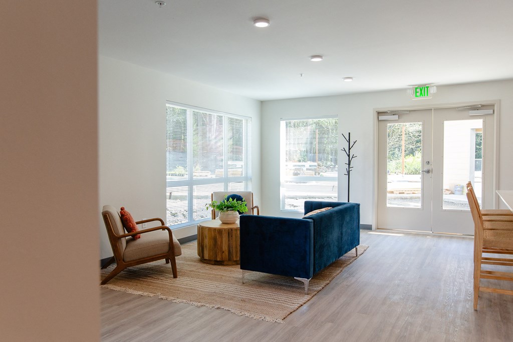 a living room with a couch and chairs in front of a door