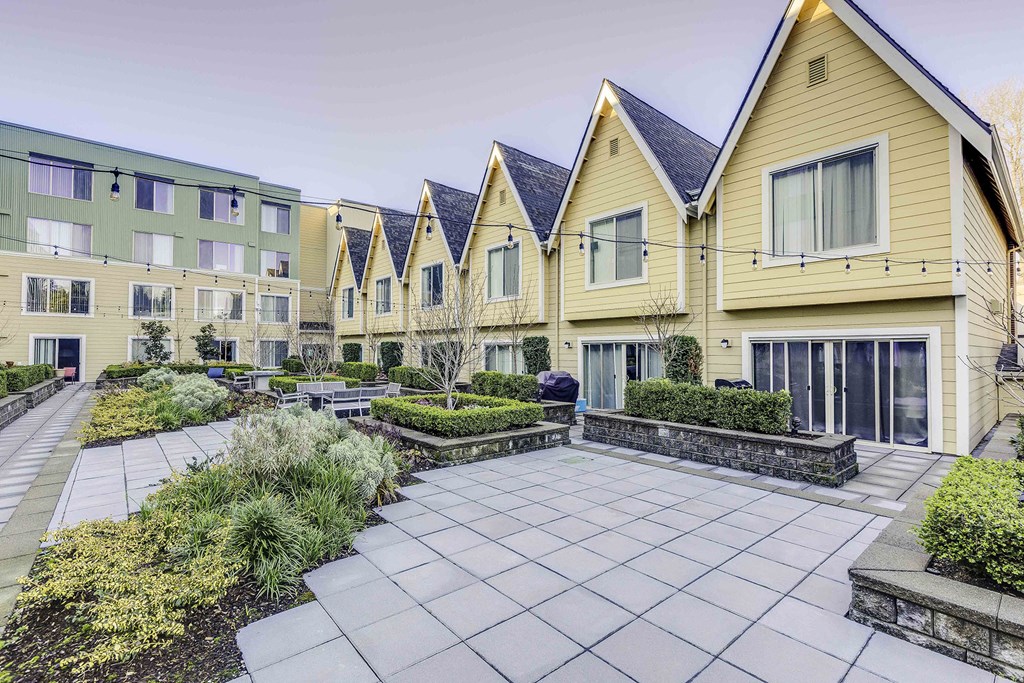 a group of yellow houses with a courtyard in front of them