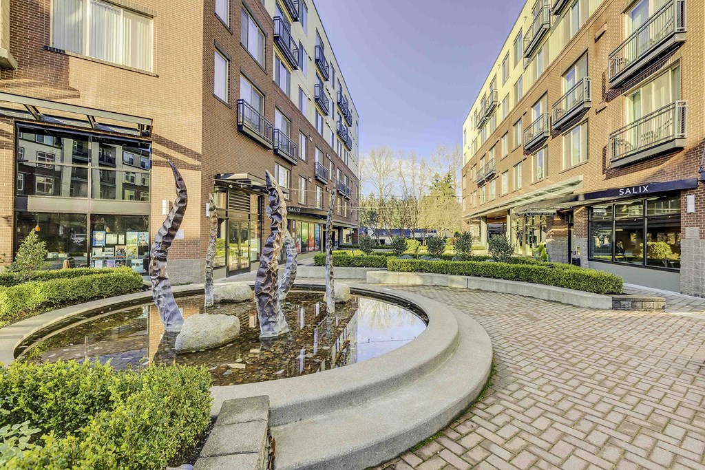 a fountain in the middle of a courtyard between two buildings