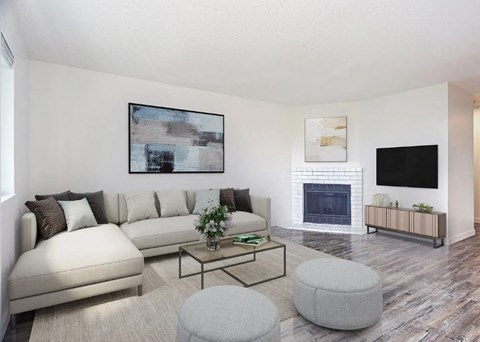 A living room with a white couch, a coffee table, and a fireplace.