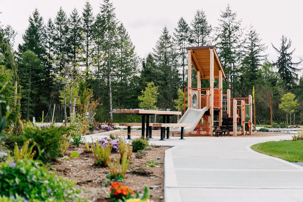 a playground with a slide and a picnic table in a park