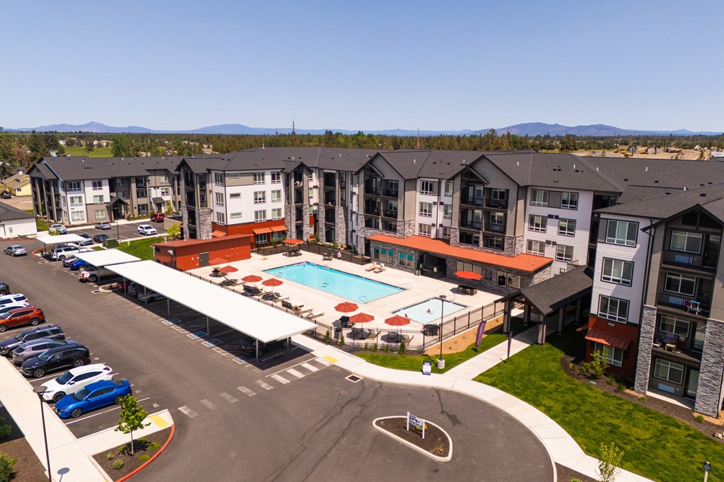 A large apartment complex with a pool and parking lot.