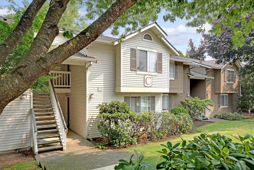 a house with stairs and a tree in front of it