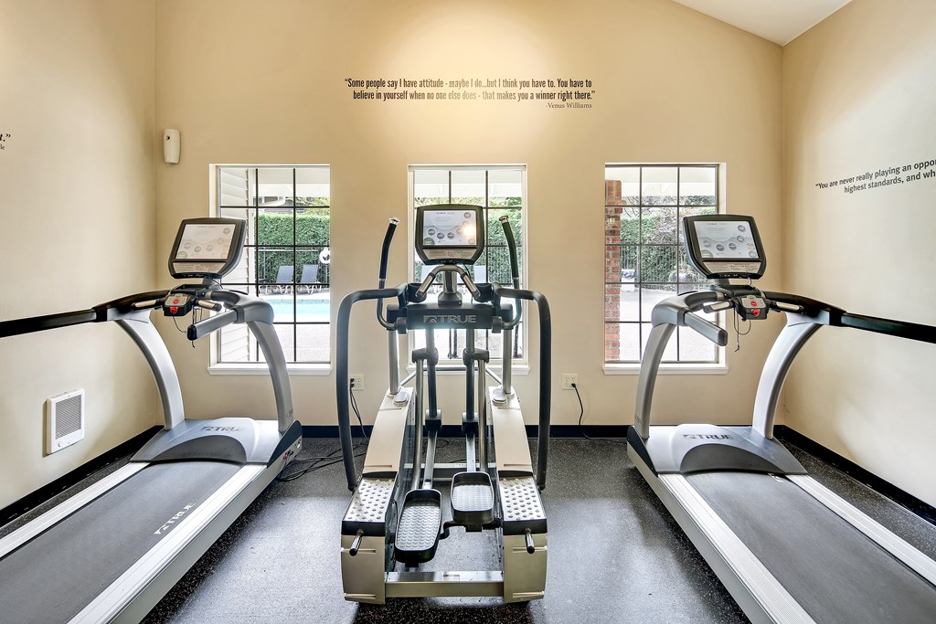 four treadmills in a gym with windows