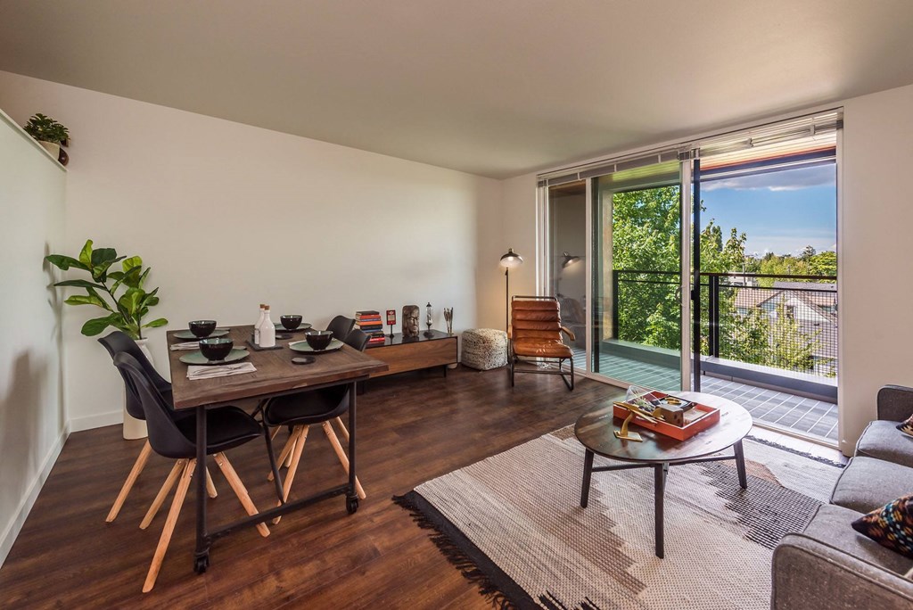a living room with a table and a balcony