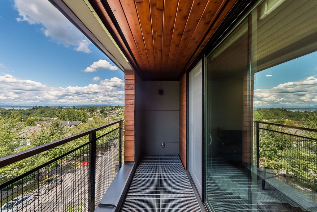 a view of the valley from the balcony of a house with glass doors
