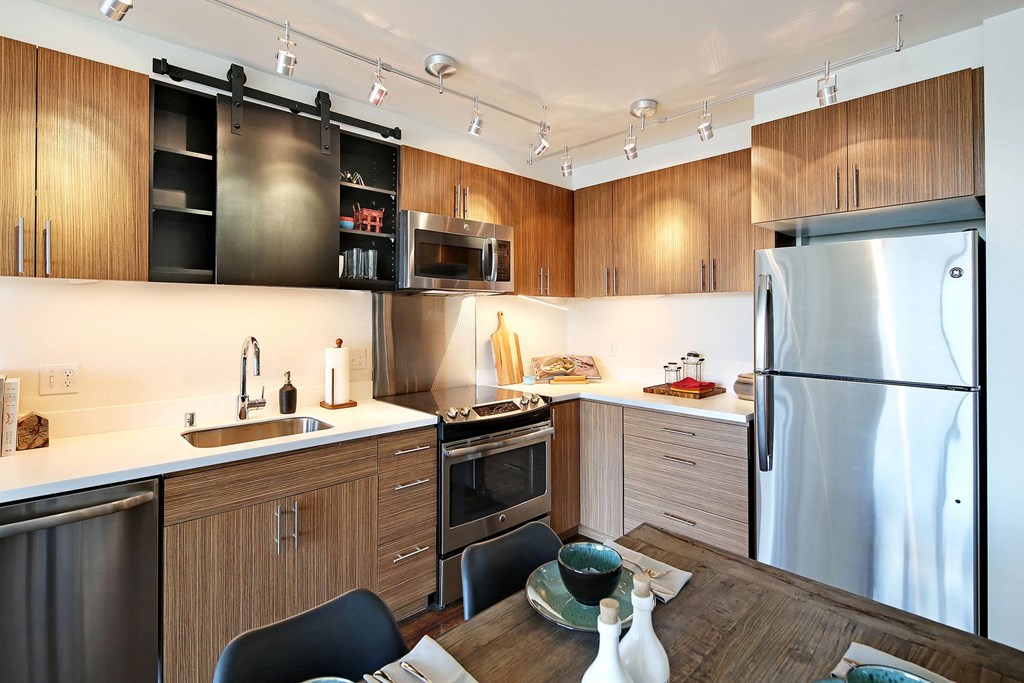 a kitchen with stainless steel appliances and a wooden table