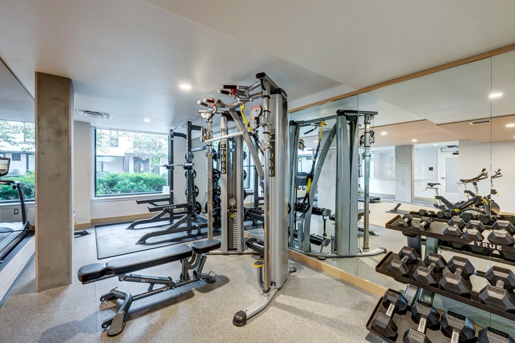 A gym with a variety of equipment including weights and machines.