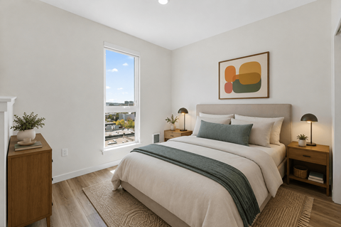 A bedroom with a large bed and a window overlooking a cityscape.