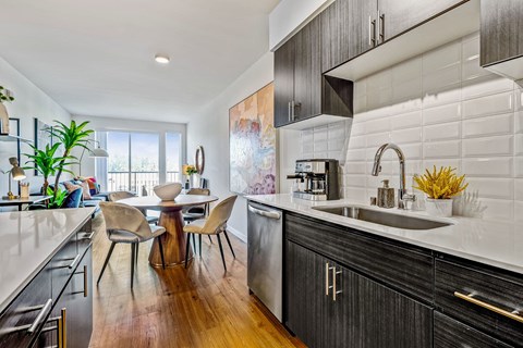 A modern kitchen with a wooden table and chairs.