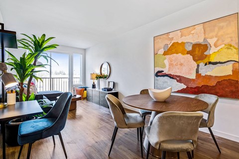 A modern dining room with a large painting on the wall.