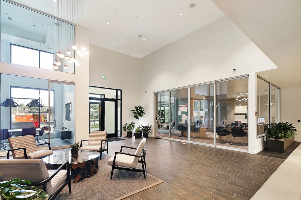 a living room with a table and chairs and large windows