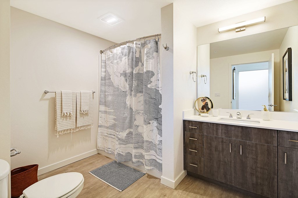 a bathroom with a shower and toilet and a sink
