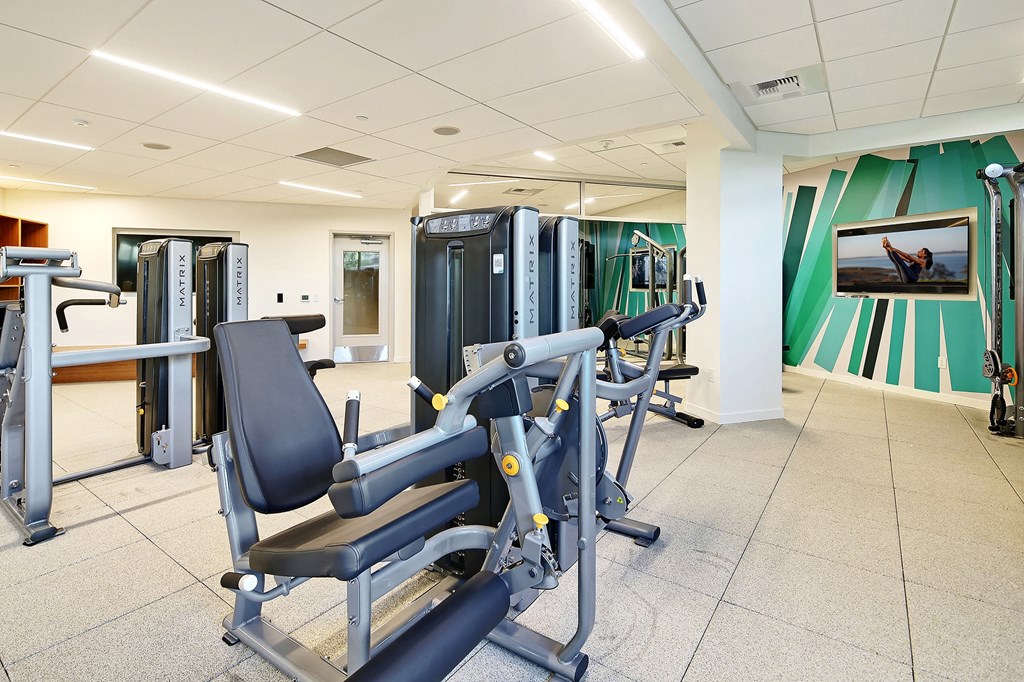 a gym with cardio equipment and weights in a building