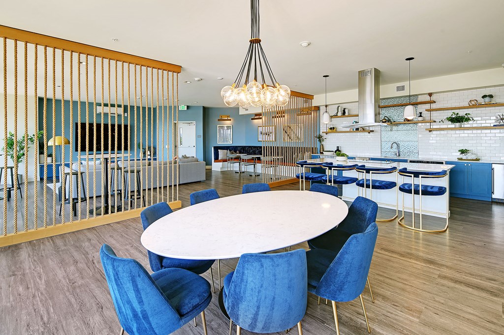 a dining room with blue chairs and a white table