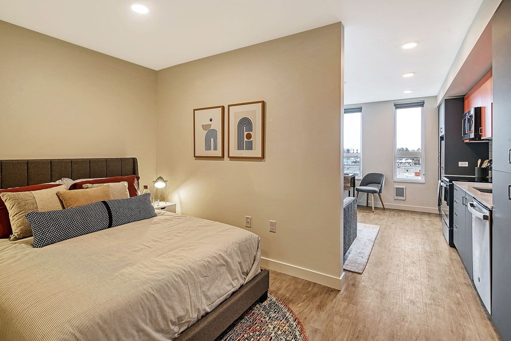 a bedroom with a bed and a living room with a kitchen