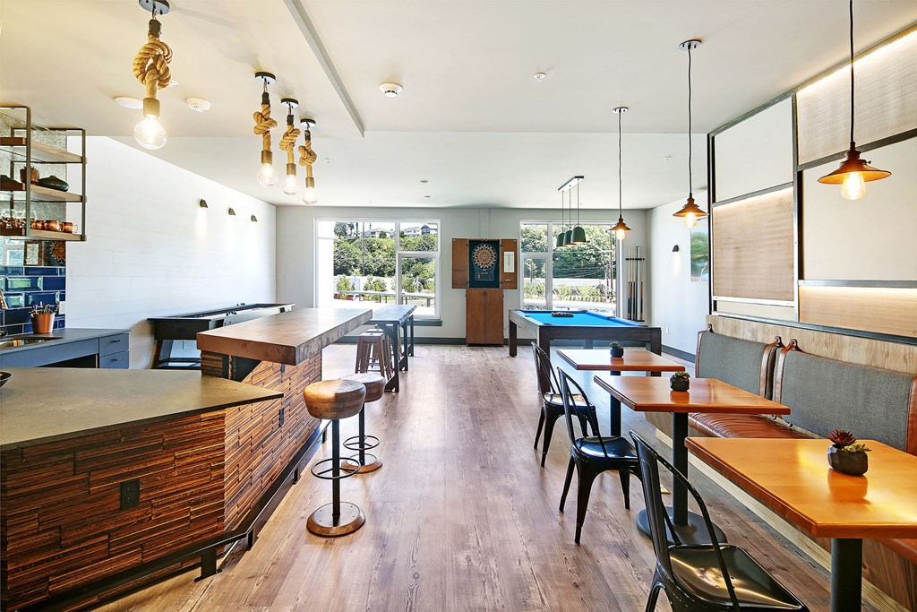 a bar with tables and chairs in a room with a pool table