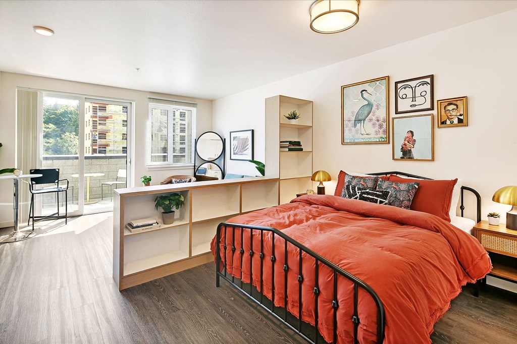 a bedroom with a bed and a desk and a window