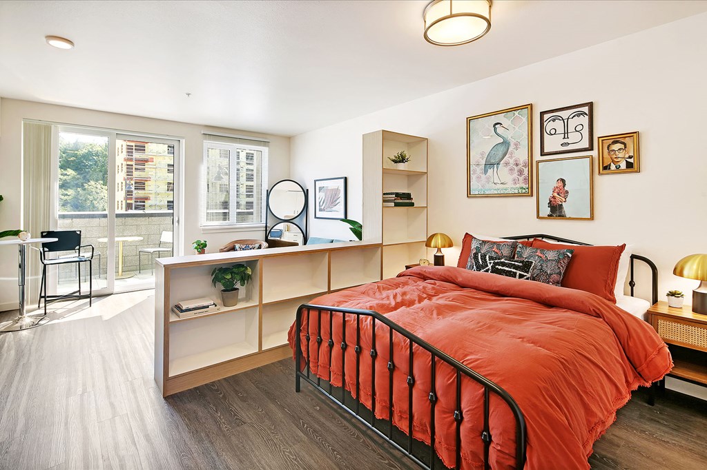 a bedroom with a bed and a desk and a window