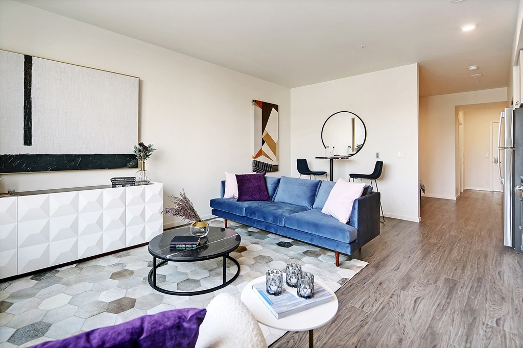 a living room with a blue couch and a table