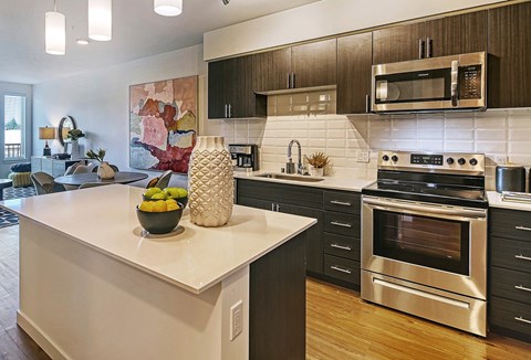 A modern kitchen with a stainless steel oven and a white countertop.