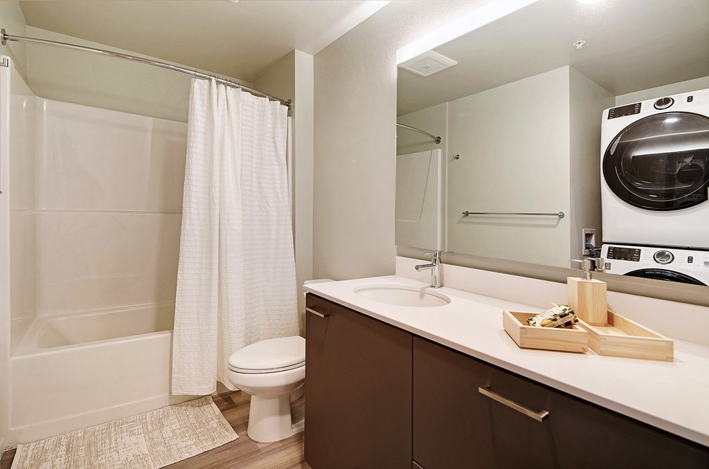 a bathroom with a toilet and a washer and dryer in it