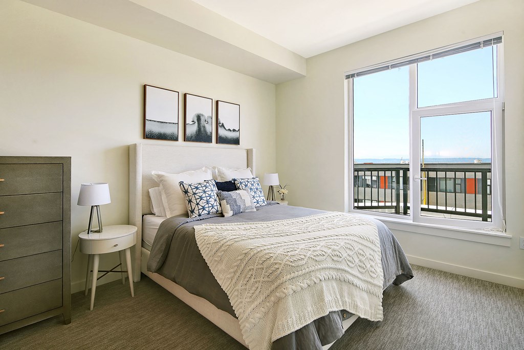 a bedroom with a bed and a large window