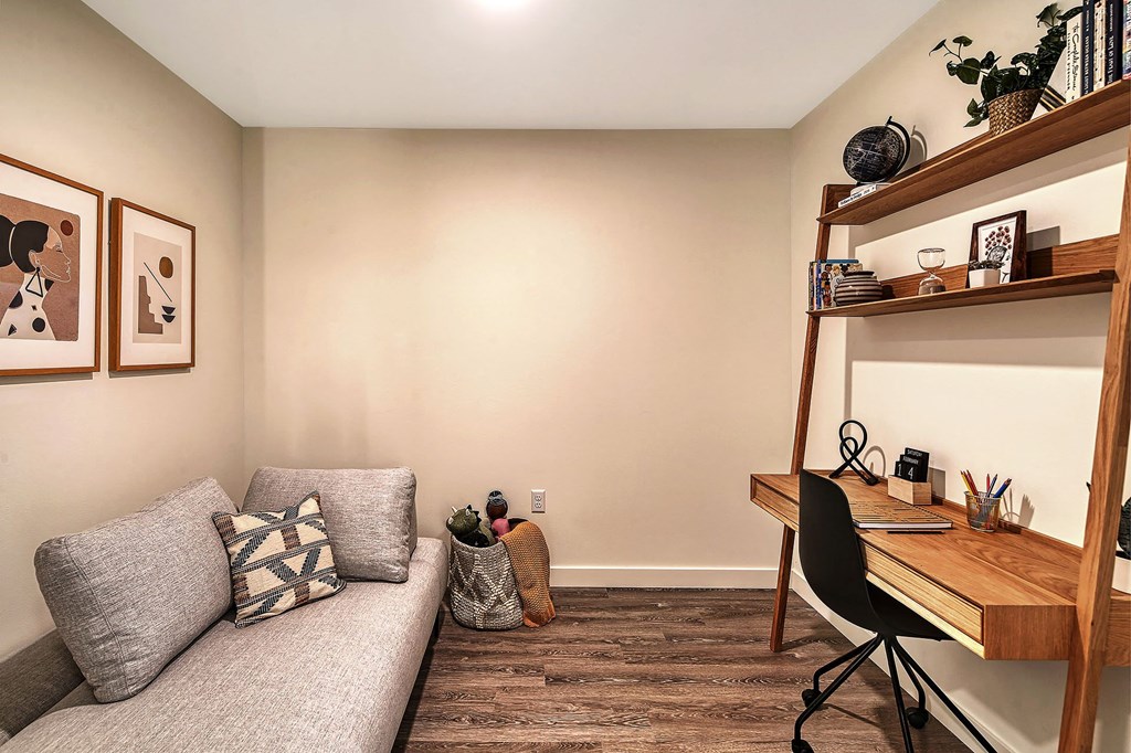 a small living room with a couch and a desk