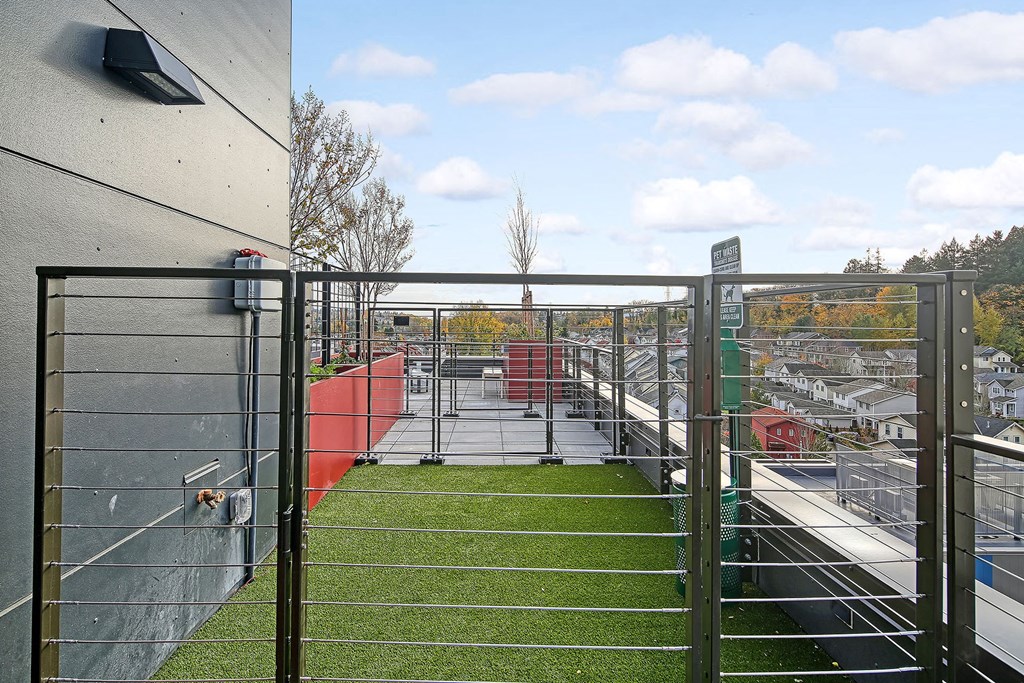 the roof terrace of the building has a grassy area and a metal fence
