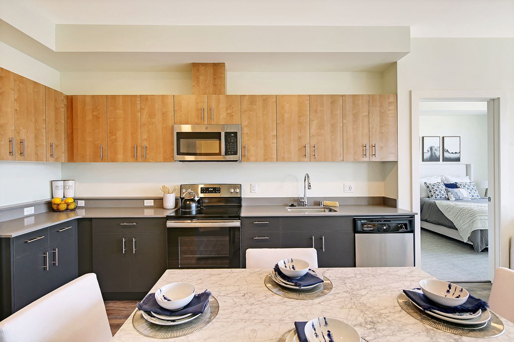 a kitchen with black appliances and wooden cabinets and a table