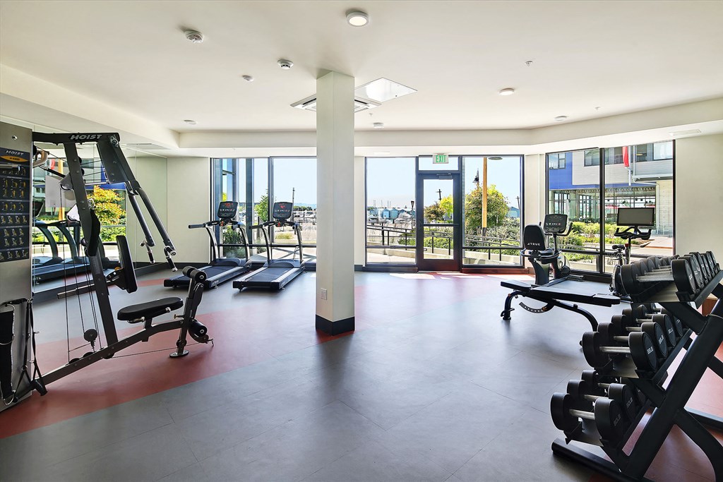 a workout room with weights and a view of a balcony