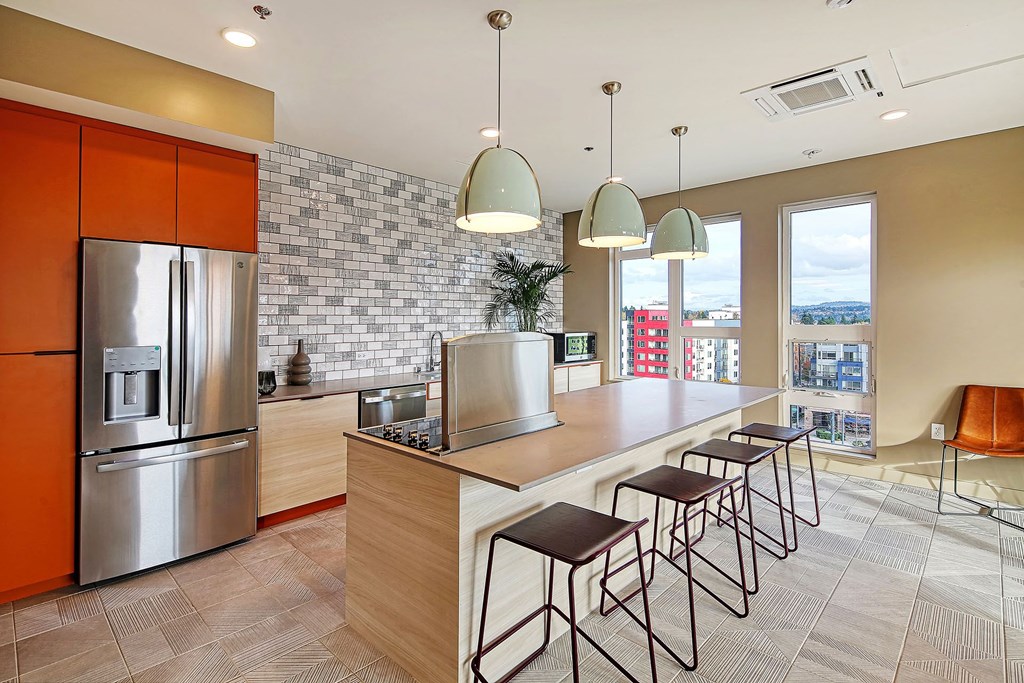 a kitchen with a large island and a stainless steel refrigerator