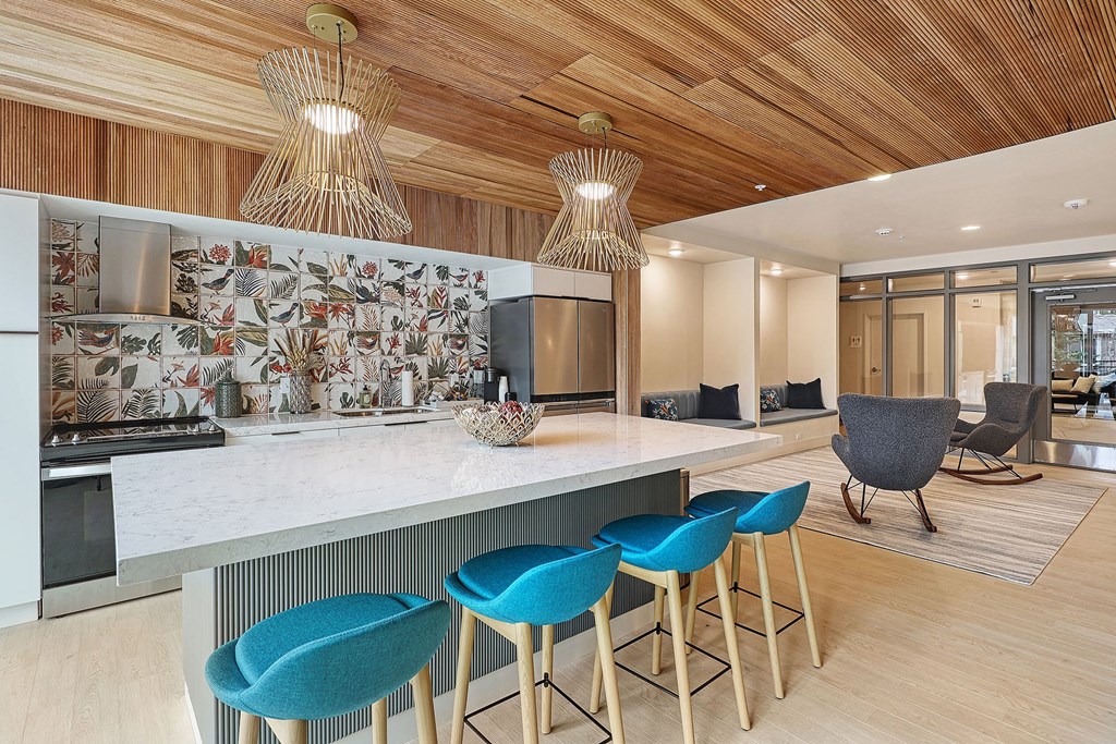 a kitchen with a white counter top and blue chairs