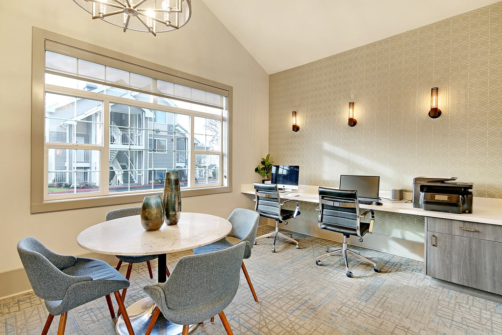 a conference room with four chairs and a table and a window