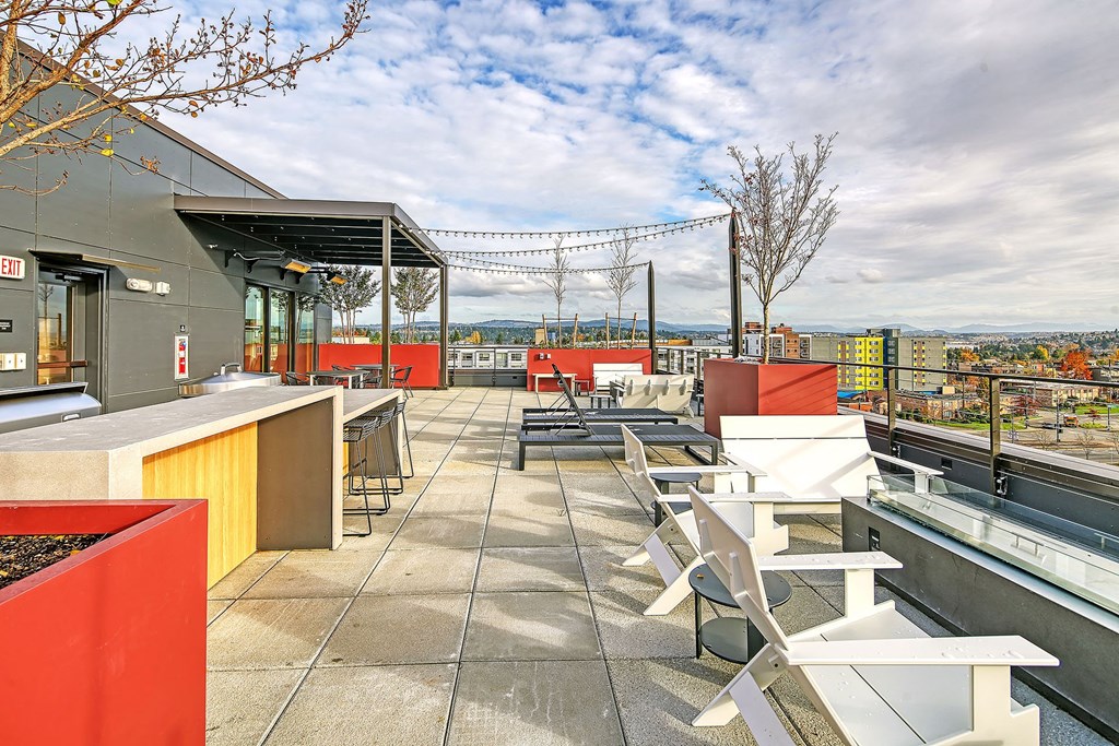 a rooftop patio with tables and chairs and a view of the city