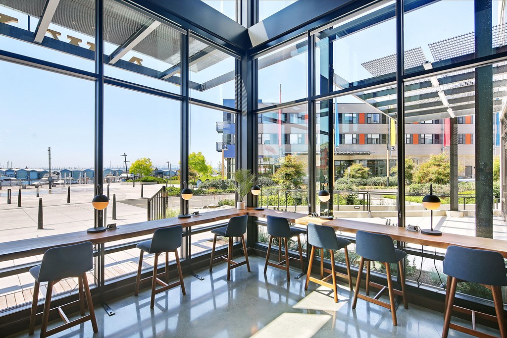a dining area with tables and chairs and large windows
