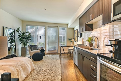 A modern kitchen with a large island and a living area with a couch and a chair.