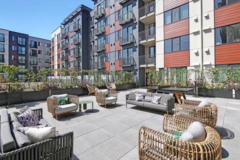 an outdoor patio with furniture in front of an apartment building