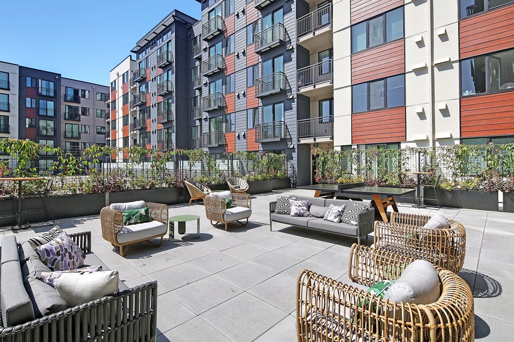 an outdoor patio with furniture in front of an apartment building